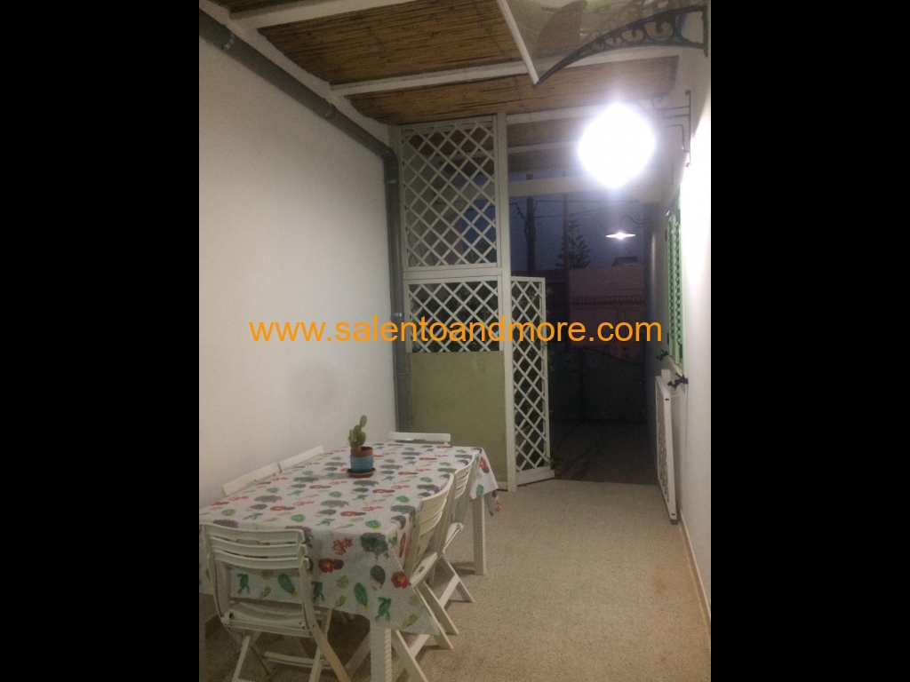 Veranda attrezzata con tavolo, sedie, barbecue per pranzi, cene e momenti di relax.